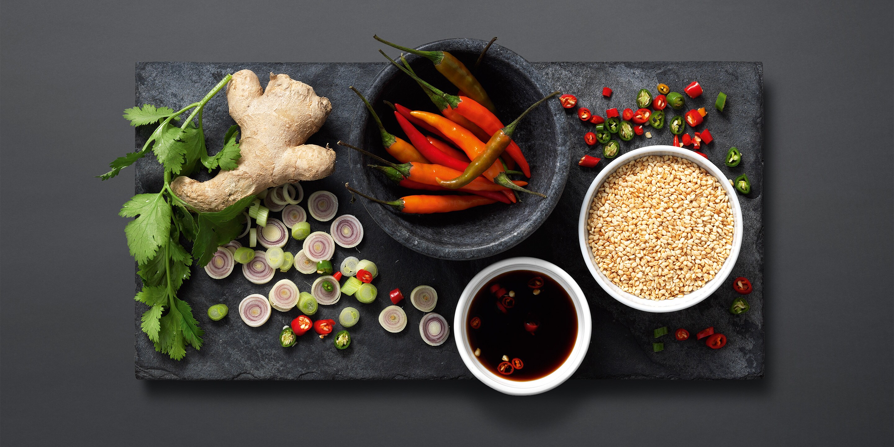 a selection of aromatic ingedients such as: ginger, chilli, spring onions and sesame seeds