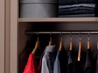 Laundered clothes hanging up in a wardobe