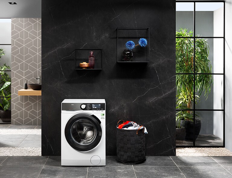 Tumble dryer with laundry basket next to it