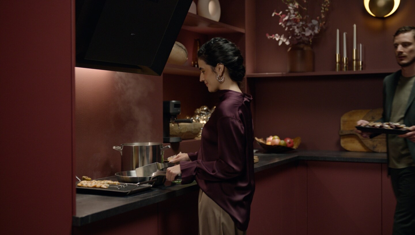 Woman and a man preparing food in a modern kitchen.