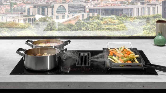 Induction hob with extractor in a kitchen with city view