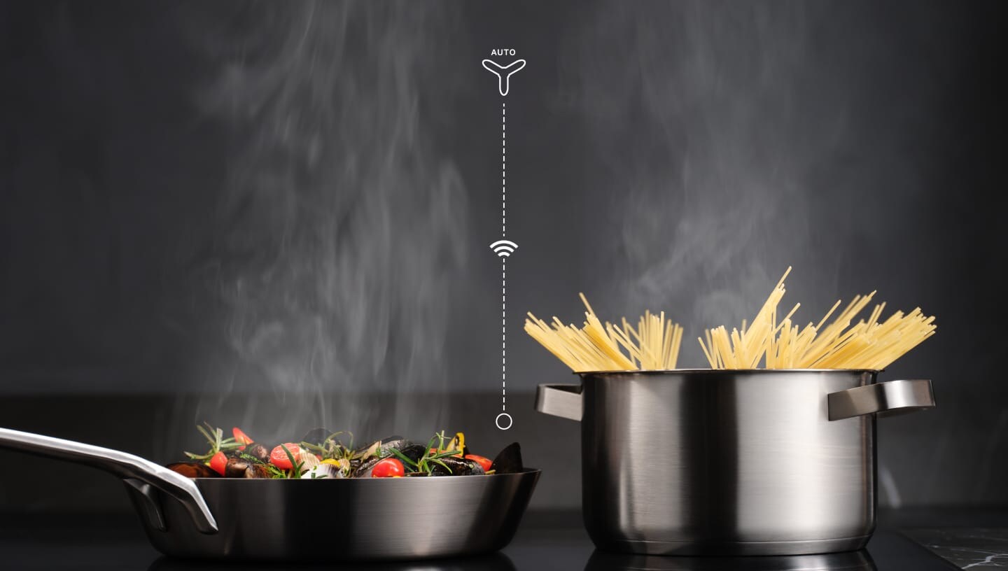 Food is being prepared on an induction hob with the Hob2Hood function.
