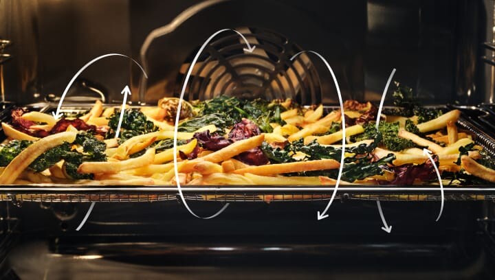 French fries and vegetables being prepared in an oven.