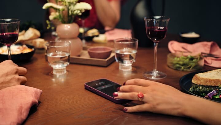 People sitting around a table with food and drink. 