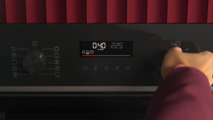 A person is clicking on an oven's control panel.