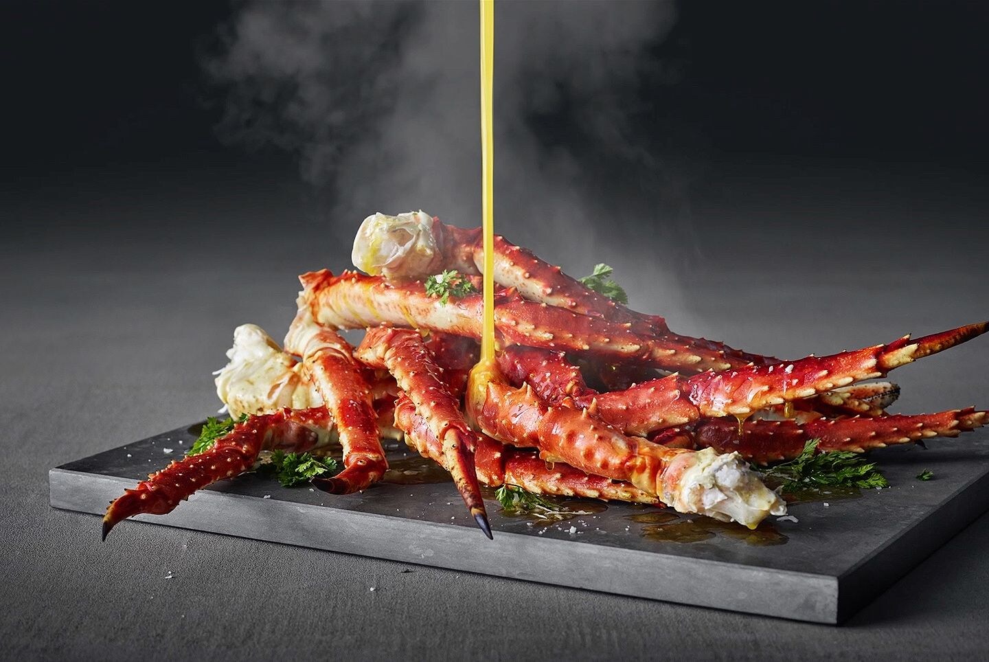 Sauce pouring onto steaming crabs legs. Sauce pouring onto steaming crabs legs.
