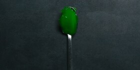 A spoon with green jelly