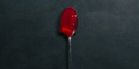A spoon with red jelly