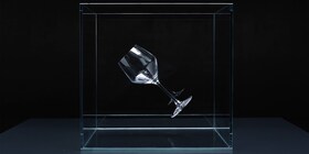 A crystal clear wine glass suspended in a cube