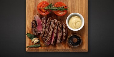 A griddled steak dinner on a wooden board