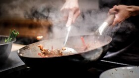 Food being cooked in a wok on an AEG induction hob