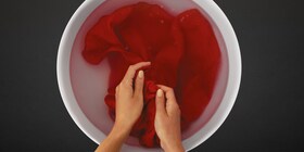 Hand washing a red garment
