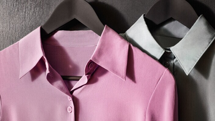 Pink and grey shirts on hangers