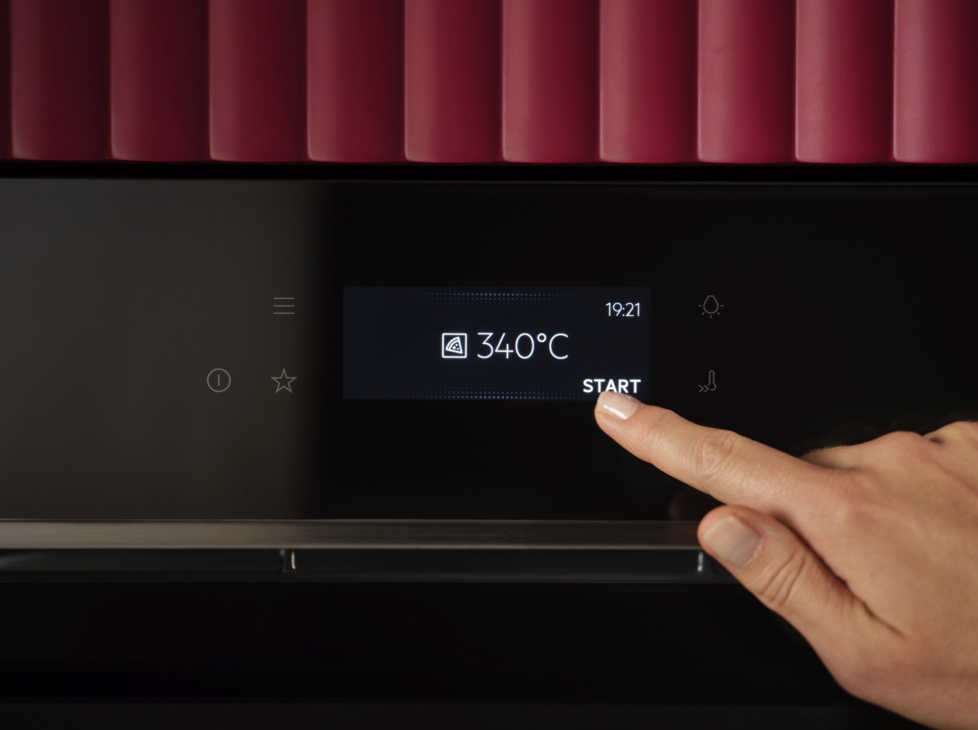 person touching the start option on the screen of an oven.