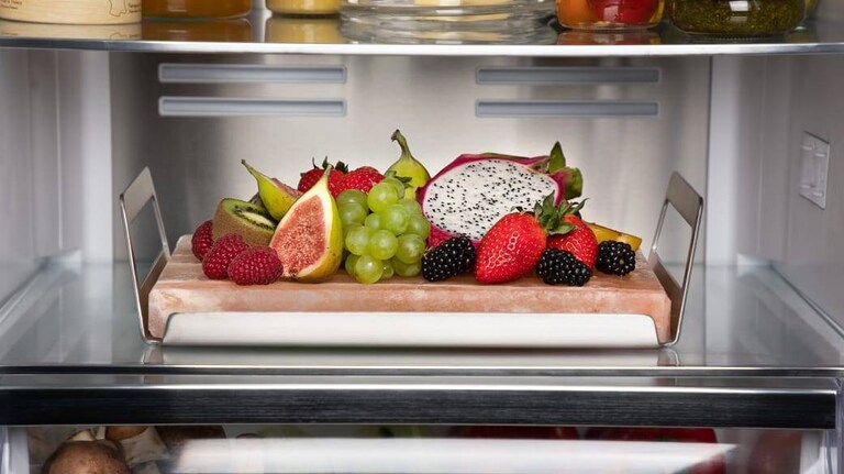 Fruits displayed on a platter inside an AEG fridge.