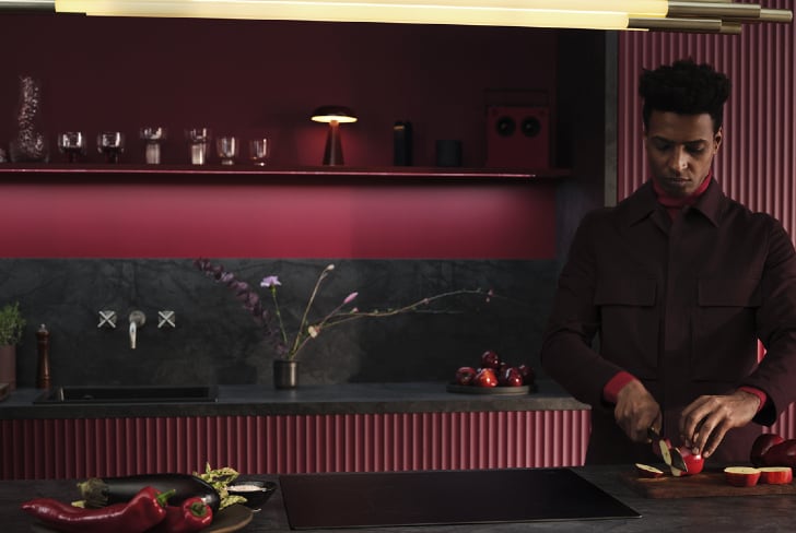 A man cutting fruit in a Kitchen